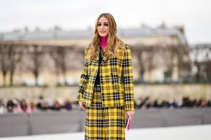 PARIS, FRANCE - MARCH 01: Olivia Palermo wears a pink turtleneck pullover, a black V-neck pullover, a black and yellow checkered print pattern blazer jacket from Dior, matching yellow and black checkered print pattern large shorts from Dior, gold rings, outside Dior, during Paris Fashion Week - Womenswear F/W 2022-2023, on March 01, 2022 in Paris, France. (Photo by Edward Berthelot/Getty Images)