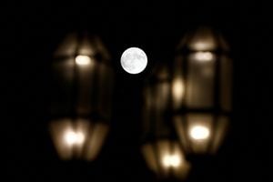 Una luna llena conocida como "Buck Moon" se ve detrás de las luces de la calle en La Valeta, Malta, el 13 de julio de 2022. Foto REUTERS/Darrin Zammit Lupi