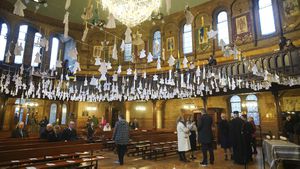 461 paper angels hang from the roof of the cathedral, one for each child that has died in the past year according to the official statistics, ahead of an ecumenical prayer service at the Ukrainian Catholic Cathedral in London, Britain, to mark the one year anniversary of the Russian invasion of Ukraine, Friday Feb. 24, 2023. (Yui Mok/PA via AP)