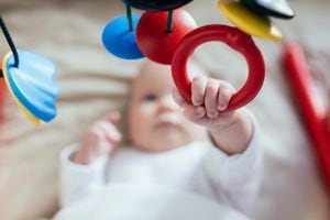 Baby playing with hanging mobile.