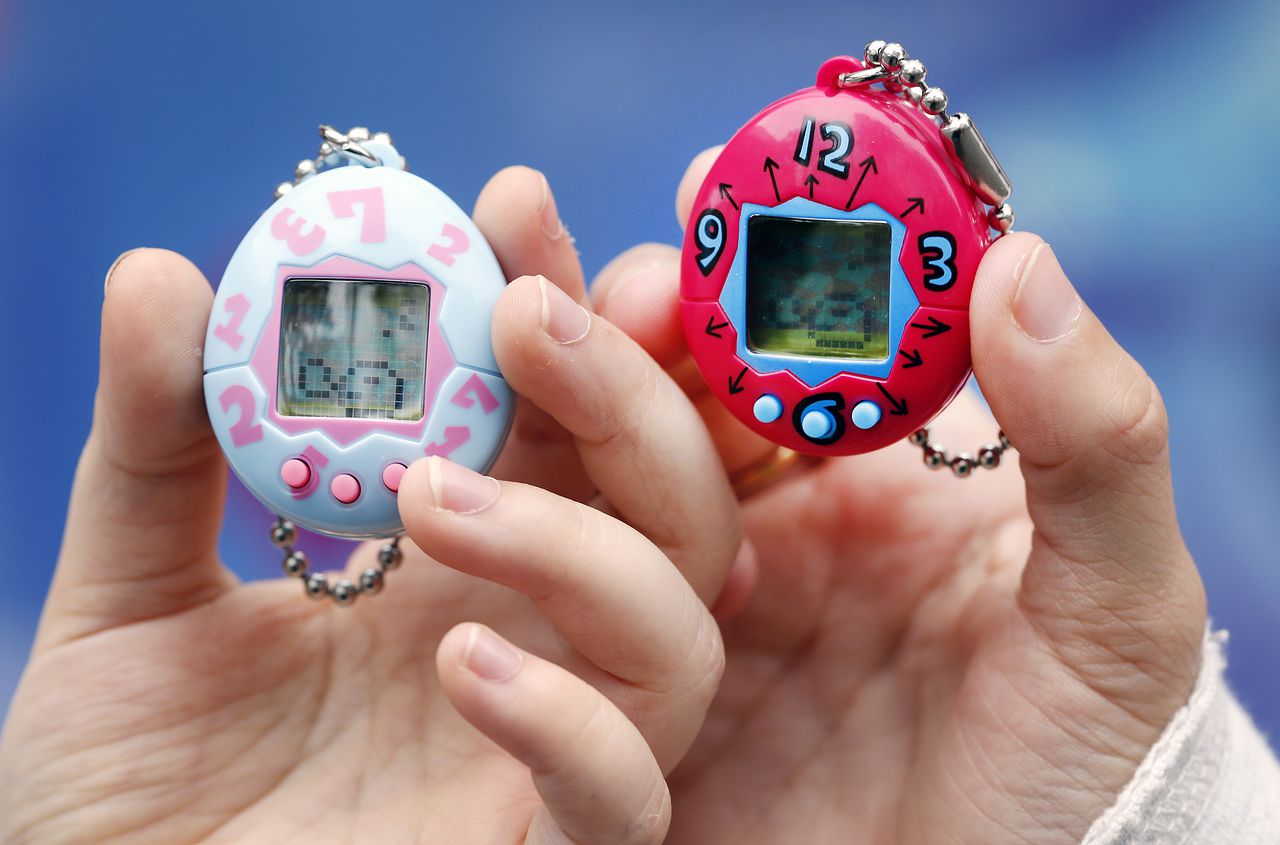 PARIS, FRANCE - OCTOBER 25:  Children show their "Tamagotchi" electronic pet on October 25, 2017 in Paris, France. Tamagotchi is a virtual electronic animal which means "cute little egg" and simulates the life of an animal. Twenty years after its creation, the Japanese company Bandai reissues the famous limited edition toy that is available today in France. Tamagotchi will be available in the United States on November 5, 2017.  (Photo by Chesnot/Getty Images)