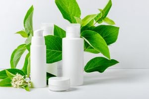 Cosmetics for moisturizing and cleansing the face. Eco cream and serum for face in white tubes and leaves of natural plants. Bio cosmetics for face and body care