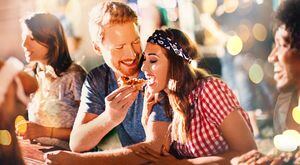 Young couple eating pizza after party.