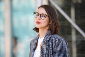 NEW YORK, NEW YORK - SEPTEMBER 14: A guest wears black sunglasses, a white cut-out / halter neck cropped top, a black and white checkered print pattern blazer jacket, outside Michael Kors, during New York Fashion Week, on September 14, 2022 in New York City. (Photo by Edward Berthelot/Getty Images)