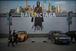 BEIJING, CHINA - OCTOBER 16: People walk in front of a Balenciaga ad on October 16, 2021 in Beijing, China. According to an action plan released on October 14, Beijing has unveiled a series of measures aimed at building the city into an international consumption center over the next five years. (Photo by Andrea Verdelli/Getty Images)