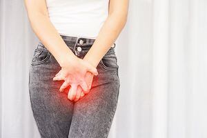 Primer plano mujer que sufre de dolor, picazón en la entrepierna mano sosteniendo su ardor vaginal causado por infecciones de la vejiga o cistitis