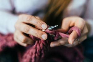 Woman knitting at home, close-up.