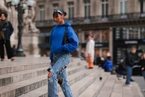 PARIS, FRANCE - MARCH 01:  Model Jamilla Strand is seen wearing a blue oversized hoodie, destroyed jeans and adidas yeezy sneaker outside Nanushka presentation, during Paris Fashion Week on March 01, 2022 in Paris, France. (Photo by Jeremy Moeller/Getty Images)