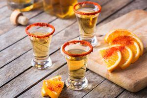 Mezcal mexicano o chupito de mezcal con ají y rodaja de naranja. Bebida alcohólica típica hecha de todo tipo de agave a diferencia del tequila en México.