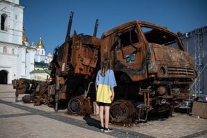 KYIV, UKRAINE - JULY 28: A young woman wearing a T-shirt in the colors of Ukrainian national flag inspects the burnt Russian military vehicles that are displayed on St. Michaels Square on July 28, 2022 in Kyiv, Ukraine. (Photo by Alexey Furman/Getty Images)