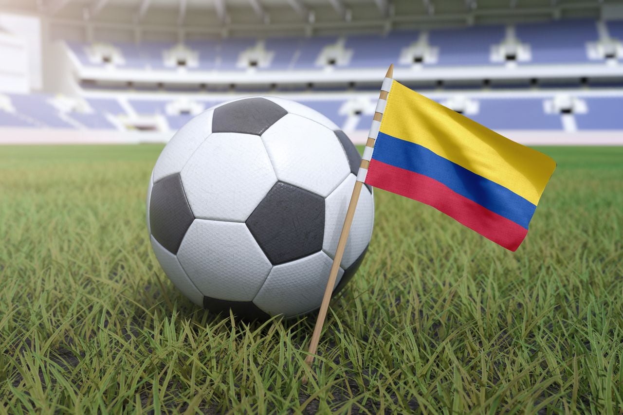 Bandera colombiana en el campo del estadio con fútbol soccer
