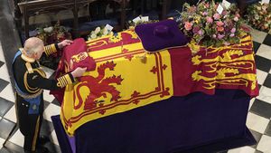 King Charles III places the Queen's Company Camp Colour of the Grenadier Guards on the coffin at the Committal Service for Queen Elizabeth II, held at St George's Chapel in Windsor Castle, Monday Sept. 19, 2022. (Jonathan Brady/Pool Photo via AP)
