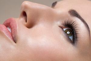 Side view of young woman with long eye lashes laying down, close up.