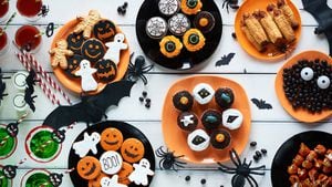 Vista de ángulo alto de galletas de Halloween, dulces, cupcakes, bebidas en mesa decorada