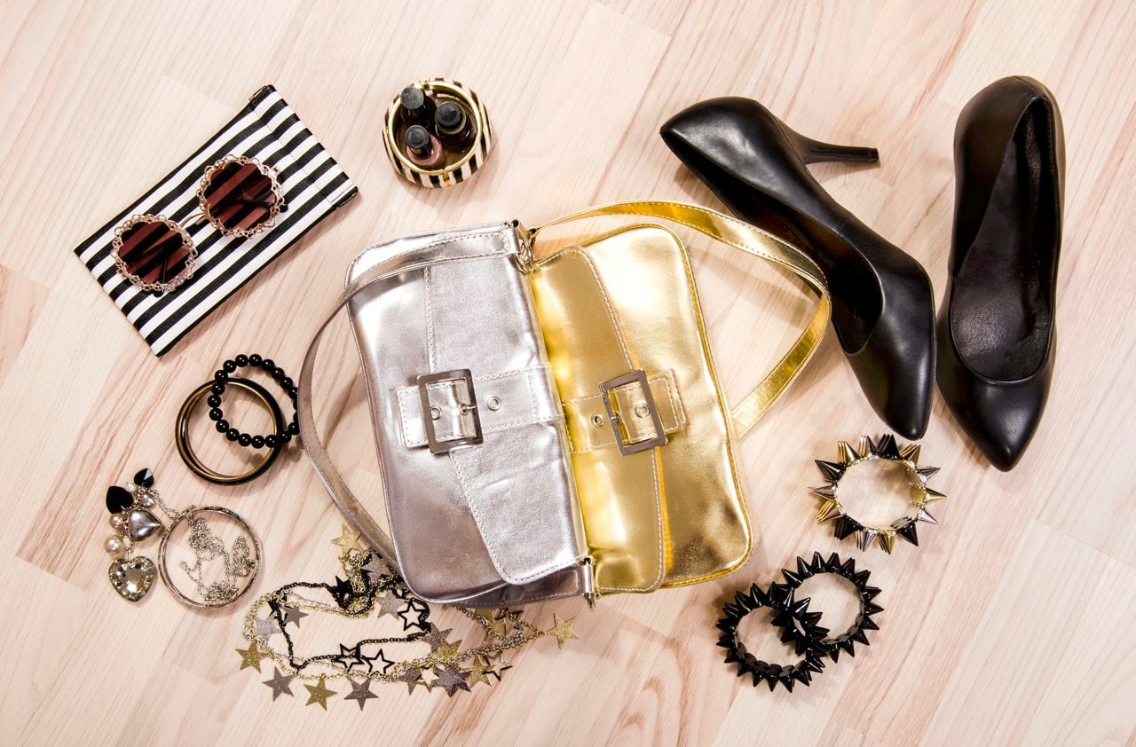 Black with gold and silver accessories, purses, high heels, bracelets, necklace and nail polish.