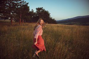 Close up of a beautiful young woman running in the field