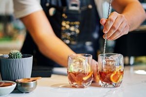 Close up of bartender mixing cocktail with bar spoon