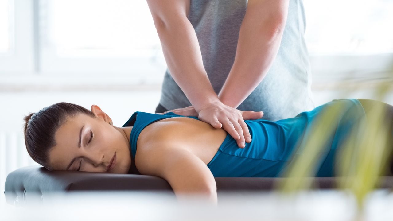 Physiotherapist massaging young woman