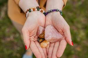 Young woman holding crystals in her arms in the park.