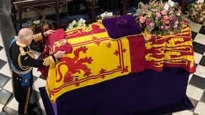 King Charles III places the Queen's Company Camp Colour of the Grenadier Guards on the coffin at the Committal Service for Queen Elizabeth II, held at St George's Chapel in Windsor Castle, Monday Sept. 19, 2022. (Jonathan Brady/Pool Photo via AP)