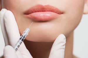 Mujer aplicándose bótox en el rostro.