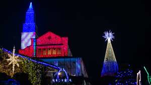 La gente disfruta de las luces navideñas de la emblemática iglesia de Monserrate en Bogotá, Colombia, el 3 de diciembre de 2022. Las decoraciones navideñas tienen como objetivo mostrar la biodiversidad de Colombia. (Foto de Sebastián Barros/NurPhoto vía Getty Images)
