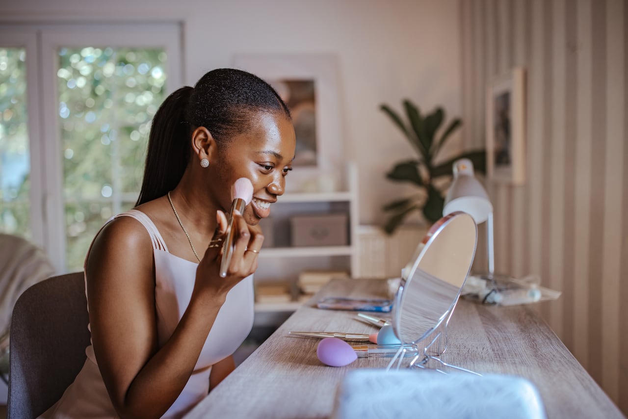 Young black girl getting glammed up for prom.