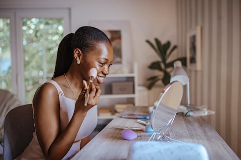 Young black girl getting glammed up for prom.