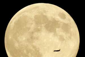 Un avión cruza al frente de la luna en su fase llena, un fenómeno llamado “luna azul”, vista desde el municipio de West Orange, Estados Unidos. (AP)