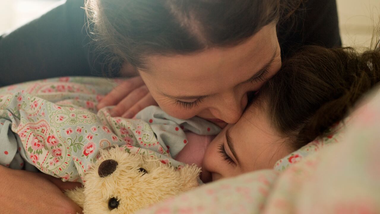 Affectionate mother with daughter in bed