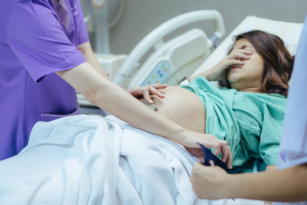 Examining the belly of a pregnant woman