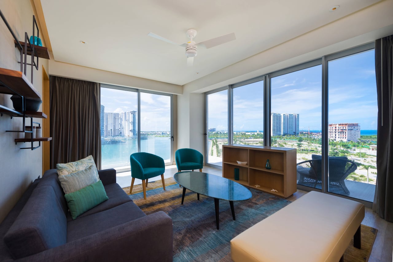 Las habitaciones y suites cuentan con ventanales y vistas hacia la marina, la bahía de Nichupté o el skyline de la ciudad, prolongando la experiencia del destino puertas adentro.