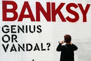 A visitor takes a picture of Logo from the exhibition 'Banksy- Genius or Vandal?' at Cordoaria Nacional, in Lisbon on June 14, 2019. This is the first major exhibition to be organized on this iconoclastic British artist, whose work has revolutionized contemporary art while his true identity continues to be unknown. The pieces, proceeding from private international collections can be seen from June 14 to October 27 at Cordoaria Nacional. (Photo by Pedro Fiúza/NurPhoto via Getty Images)