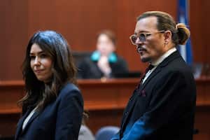US actor Johnny Depp stands next to his lawyer Camille Vasquez after a break in the defamation trial against ex-wife Amber Heard at the Fairfax County Circuit Courthouse in Fairfax, Virginia, on May 18, 2022. - Depp is suing ex-wife Amber Heard for libel after she wrote an op-ed piece in The Washington Post in 2018 referring to herself as a �public figure representing domestic abuse.� (Photo by KEVIN LAMARQUE / POOL / AFP)