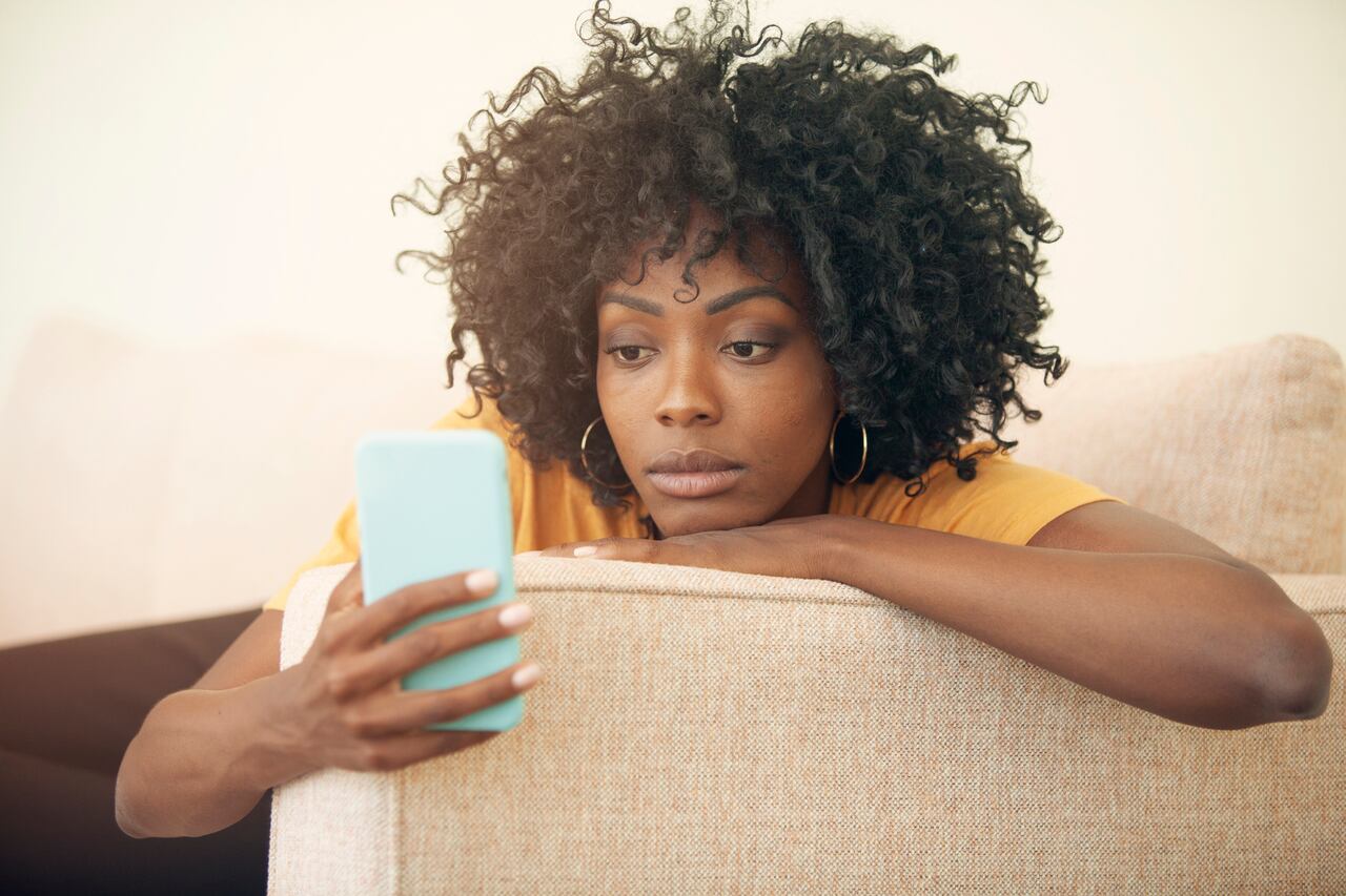 Mujer mirando aburrida el celular