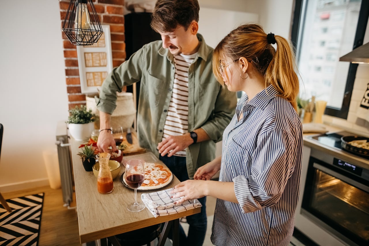 Young smiling couple baked a pizza in the kitchen