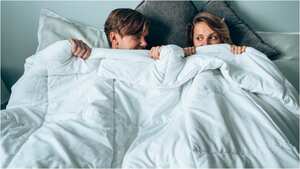 Pareja metida entre las cobijas