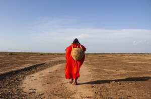 LA GUAJIRA, COLOMBIA - 24 DE SEPTIEMBRE: Una mujer lleva una canasta mientras camina sobre un terreno seco cerca del río Ranchería, donde vive el pueblo wayuu, luego de enfrentarse a la expansión de la mina de carbón Cerrejón en La Guajira, Colombia el 24 de septiembre. En el Provincial Reserva, una región semidesértica de Colombia, Cerrejón (la mina de carbón a cielo abierto más grande de Colombia y América Latina, y la décima más grande del mundo) ha creado desigualdades ambientales, problemas cardiovasculares, daños en la piel y contaminación. El río Ranchería ha transformado la dinámica del agua, afectando a los Wayuu. (Foto de Lis Mary Machado/Agencia Anadolu vía Getty Images)