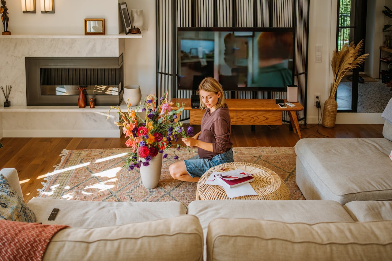 Florist woman during pregnancy arranges flowers to enhance her living space and organizes her surroundings