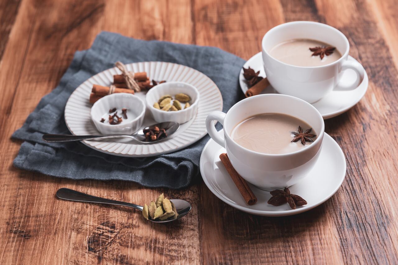Indian masala chai tea. Spiced tea with milk on the rustic wooden table.