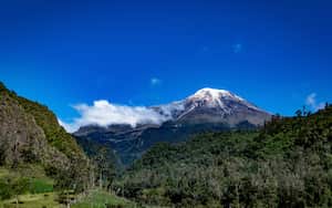Beautiful view of the Tolima snowy peak contrasted in a bright blue sky with few clouds taken from the outskirts of Ibague Tolima