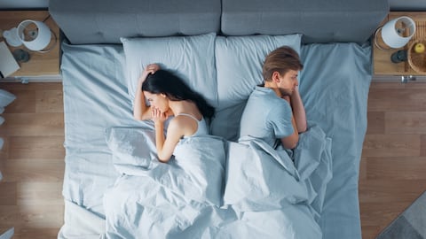 Pareja triste en cama