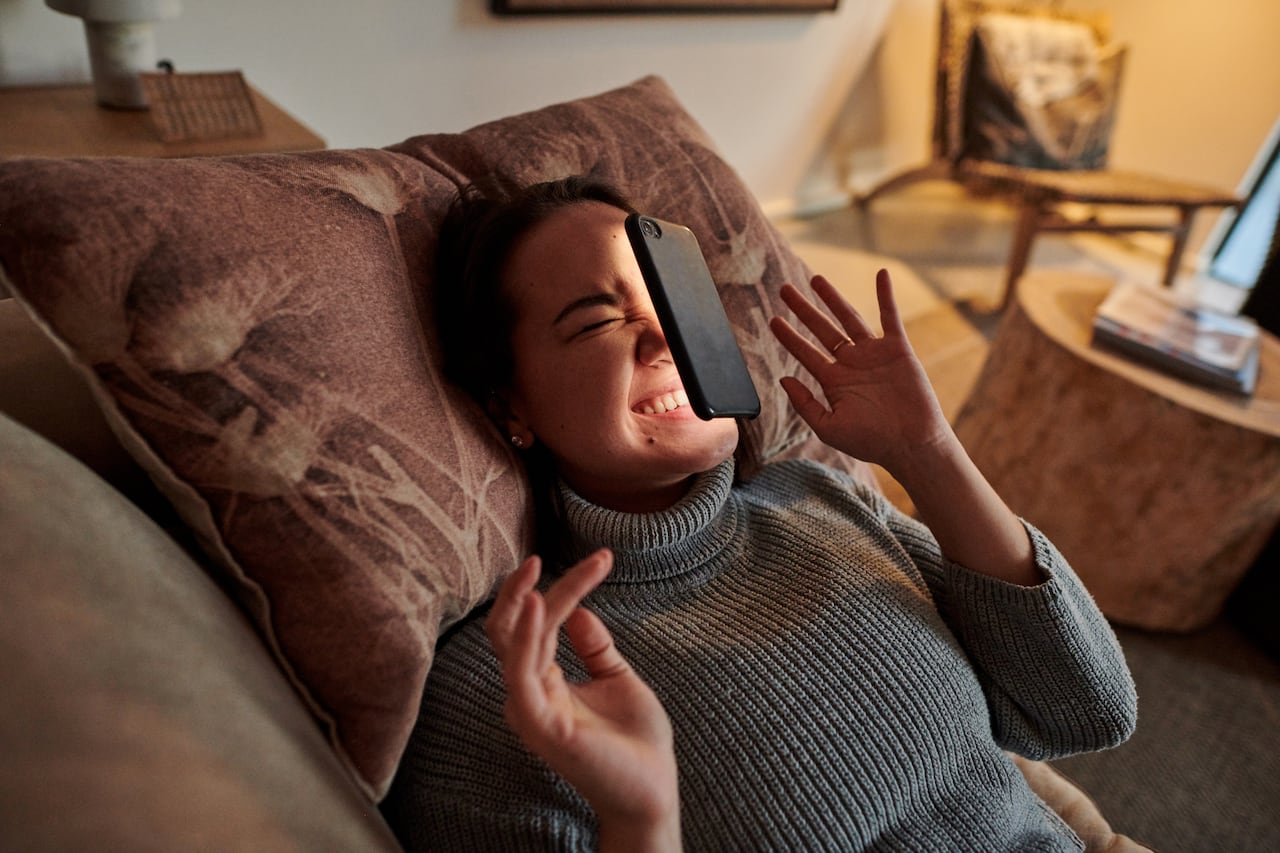 Mujer que se queda pegada a su celular y este le cae en la cara.