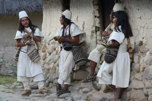 NABUSIMAKE, COLOMBIA - JANUARY 23, 2015: Typically dressed Arhuaco men stand outside a hut in the walled village (Pueblito) on January 23, 2015 Nabusimake, Colombia. The Arhuacos appear in white serapes, and carry beautifully stitched handbags (Mochilas) slung across lean shoulders. Nabusimake is the spiritual center of the Arhuaco indigenous people and the place where they say the sun was born. Located high in the Sierra Nevada mountains, the community and their way of living inspire a spiritual stillness and the surrounding area is alive with virgin forests, waterfalls, and birds. (Photo by Kaveh Kazemi/Getty Images)