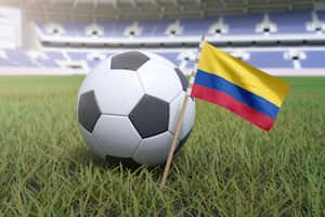 Bandera colombiana en el campo del estadio con fútbol soccer