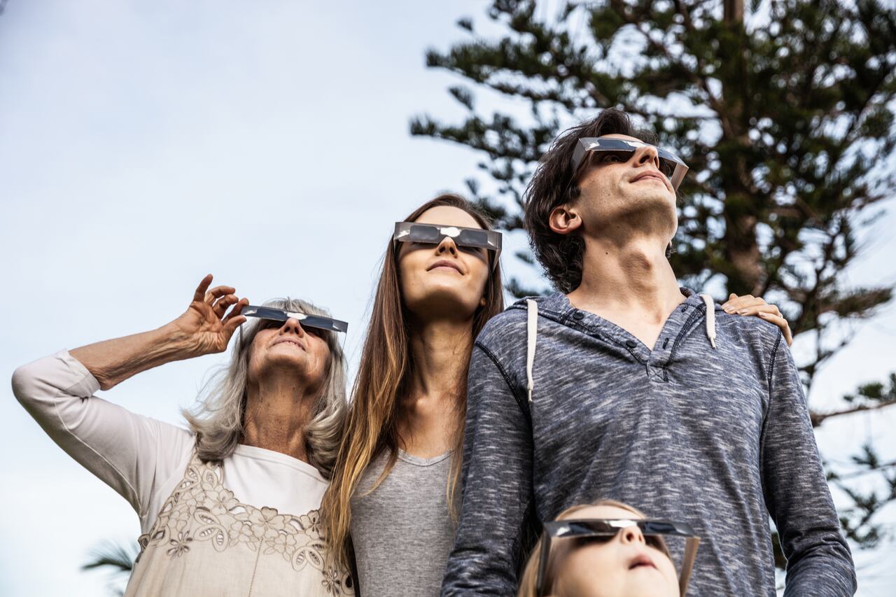 Familia viendo un eclipse con protección en los ojos
