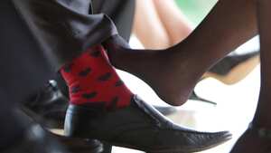 ambiente de oficina, jugando con los pies. Mujer juega con sus pies por debajo de la mesa, juego de amantes, infidelidad, infieles. Mujer rosa su pie con el pie de un hombre, coqueteo.