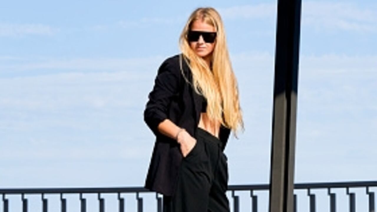 Close-up of young blonde standing with dark glasses looking at camera