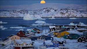 El primer sol naciente después de tres meses de total oscuridad, produce expectación en esta parte de Groenlandia. La vida de los próximos meses transcurrirá bajo un cielo teñido de púrpura, y un sol tímido y suave.