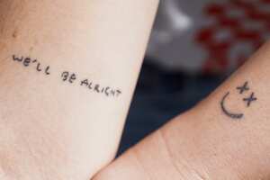 20 May 2022, Berlin: Saskia (l) and Leonie show off their tattoos in front of the entrance to "Harry's House," the pop-up store of musician Harry Styles on Rosa-Luxemburg-Strasse in Berlin-Mitte. The tattoos remind them of their idol, singer Harry Styles. The store is scheduled to open today. In the store there will be limited merchandise for the upcoming record. Photo: Joerg Carstensen/dpa (Photo by Jörg Carstensen/picture alliance via Getty Images)